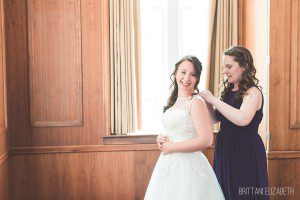 bridesmaid helping bride get ready