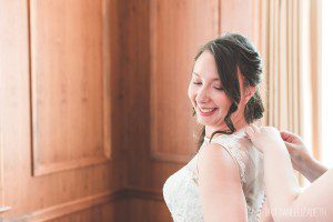 bride getting ready putting lace dress on