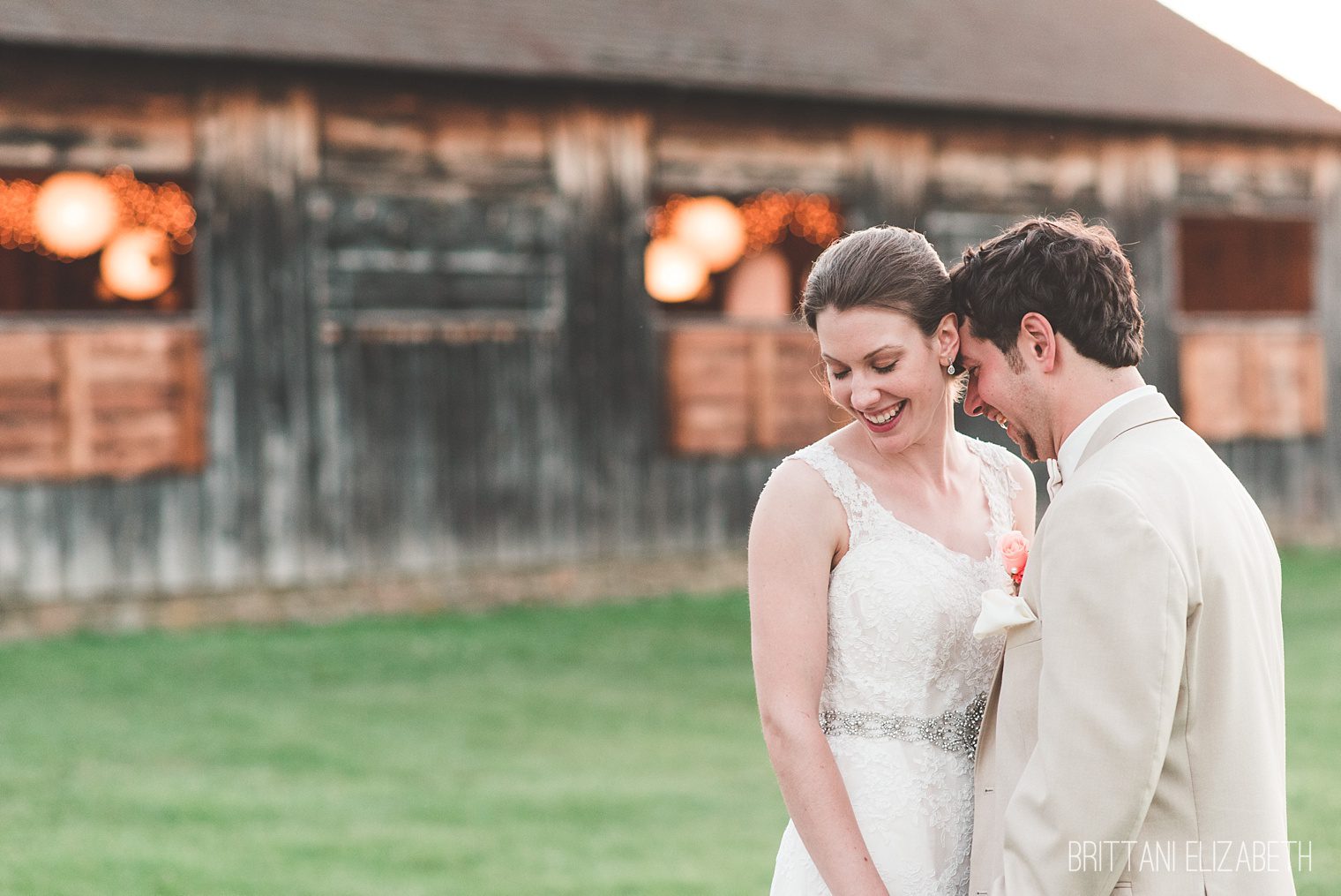 bride and groom nuzzling outside wooden barn union mills homestead