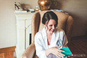 candid bride getting ready monogrammed robe updo hairstyle