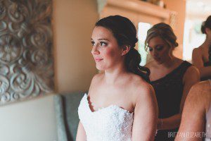 bride putting on sweetheart neckline lace wedding dress