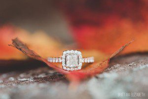 square halo diamond engagement ring on orange leaf