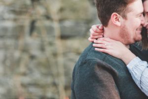 engaged couple nuzzling fallen tree farm