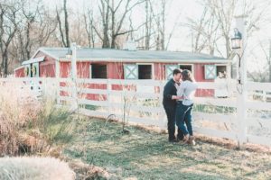 engaged couple in front of barn fallen tree farm