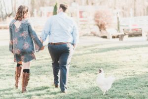 engaged couple walking holding hands chicken fallen tree farm