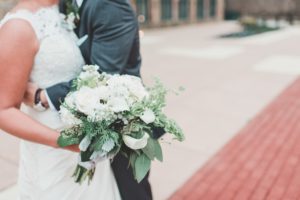 bride and groom with white and green bouquet winter wedding