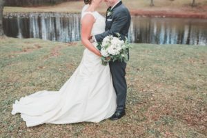 bride and groom outside by pond winter wedding