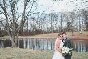 bride and groom holding each other pond woods winter wedding