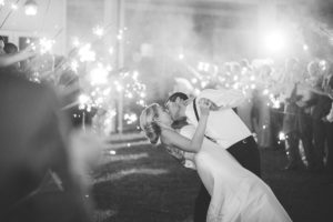 black and white groom dipping bride sparkler send off