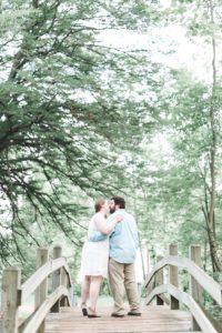 engaged couple kissing on wooden bridge in valley forge