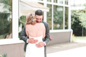 bride and groom embrace after first look sussex conservatory