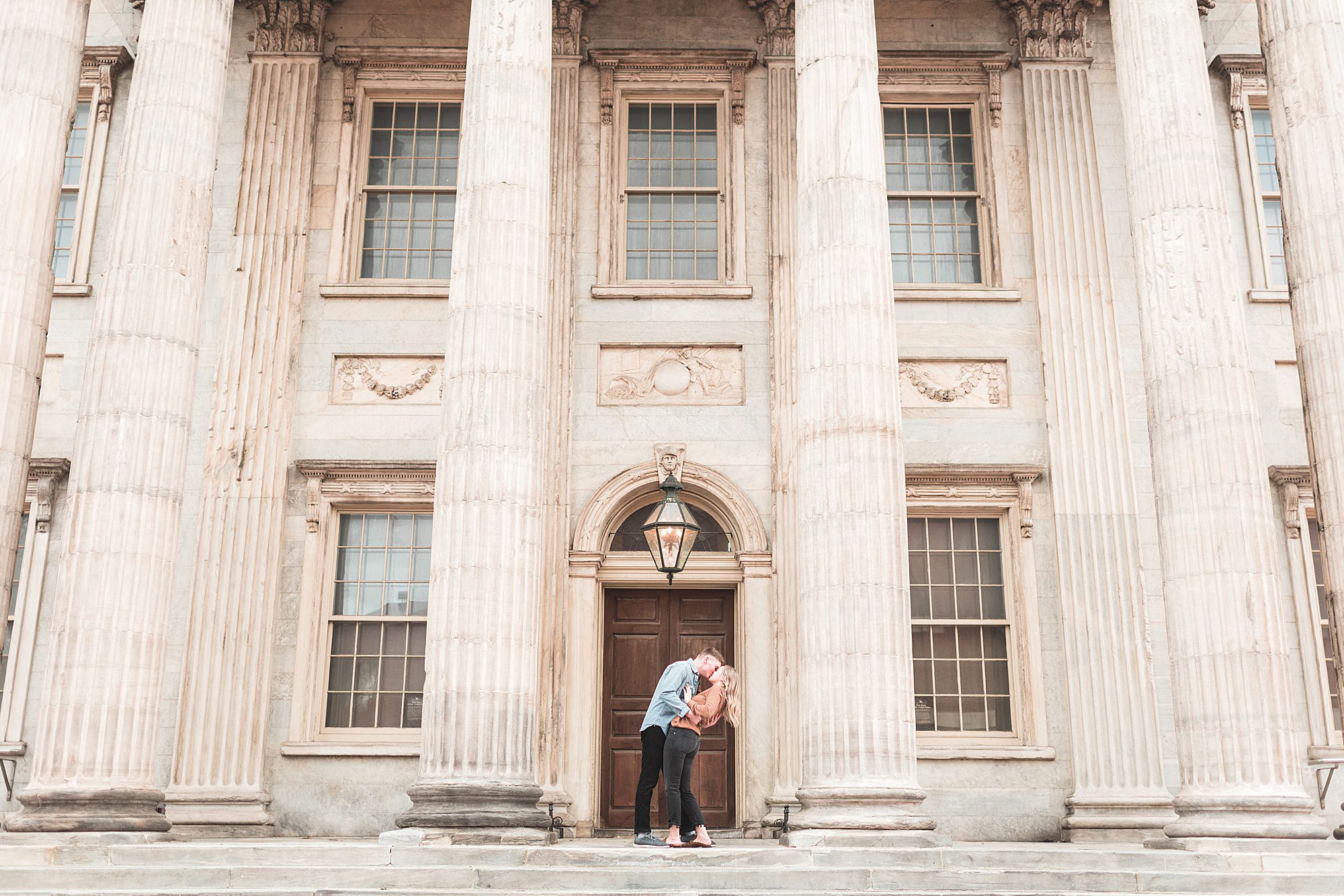 Engaged couple kisses at First Bank of the United States