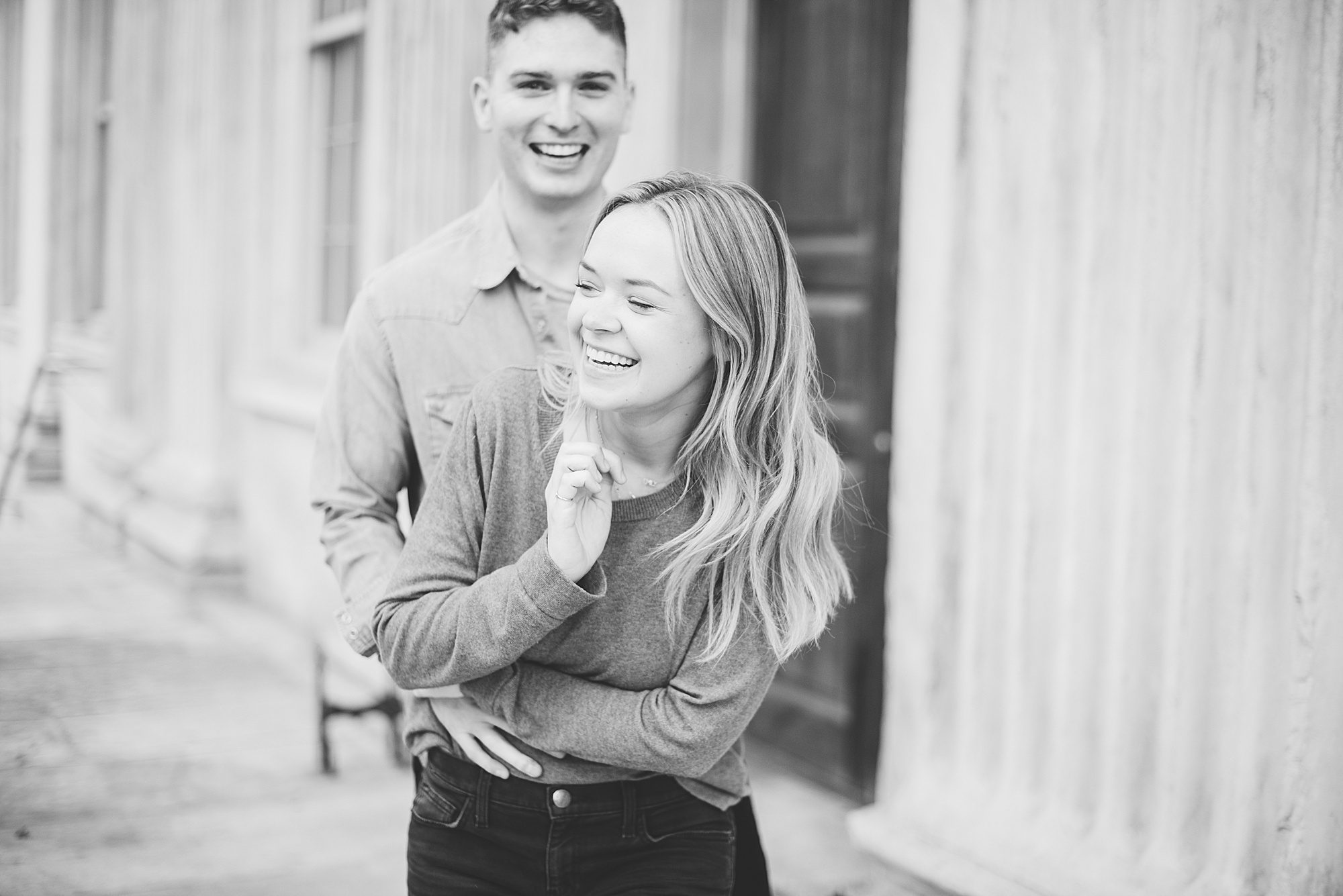 Engaged couple laughs outside of the First Bank of the United States 