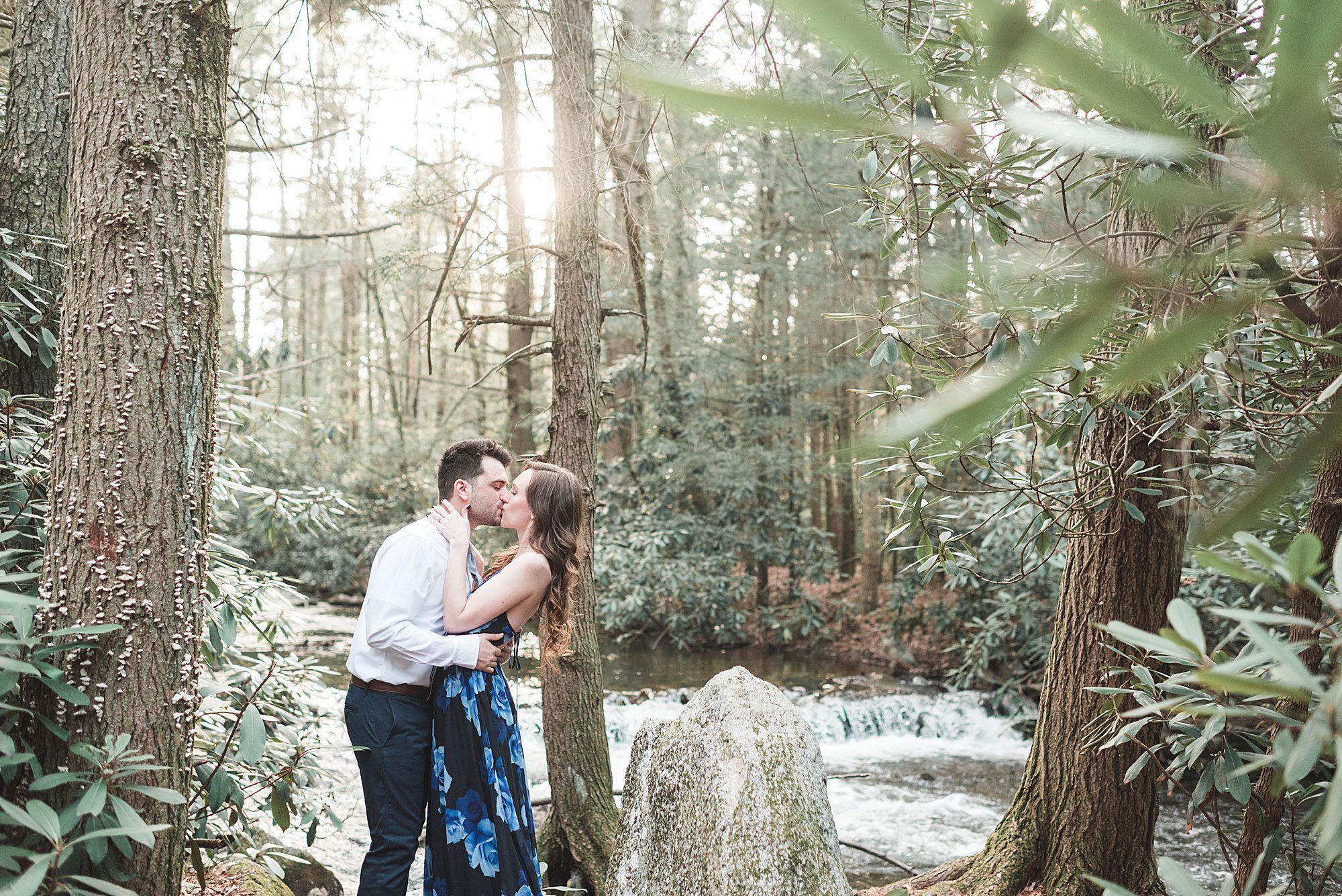 Engaged couple kisses by waterfall in the woods in Jim Thorpe Pennsylvania